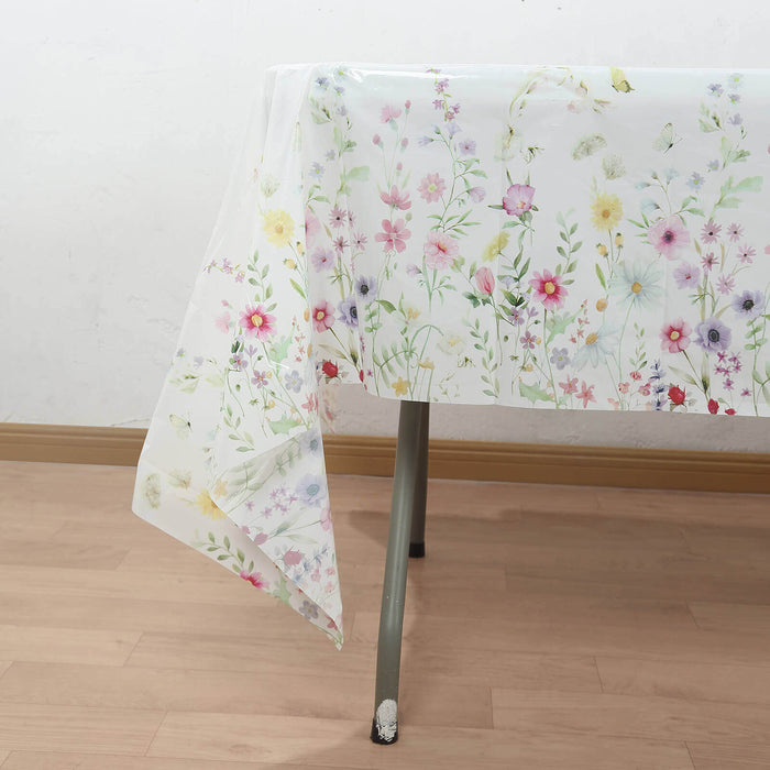 Floral tablecloth draped over a table, featuring colorful flowers on a white background.