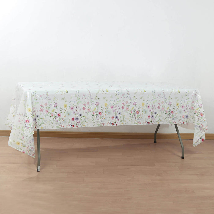 Floral tablecloth draped over a folding table in a light setting.