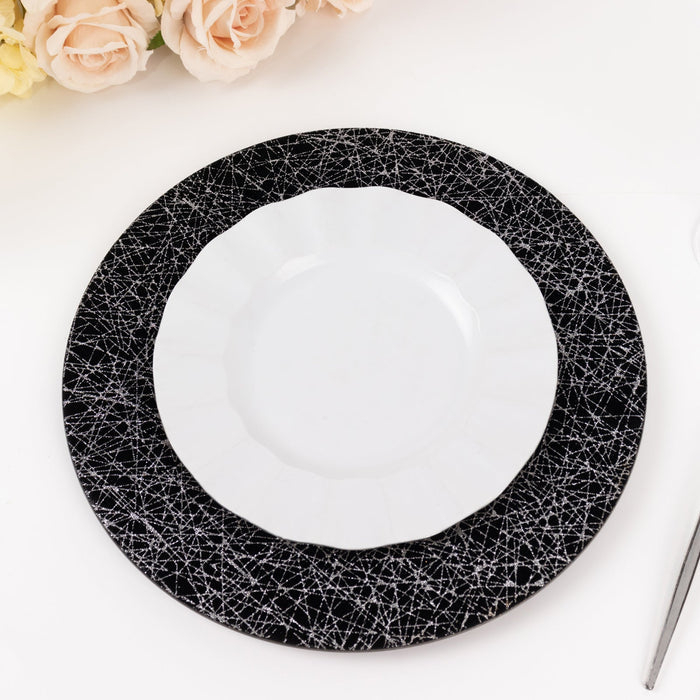 Black and white decorative plates stacked on a table with roses.