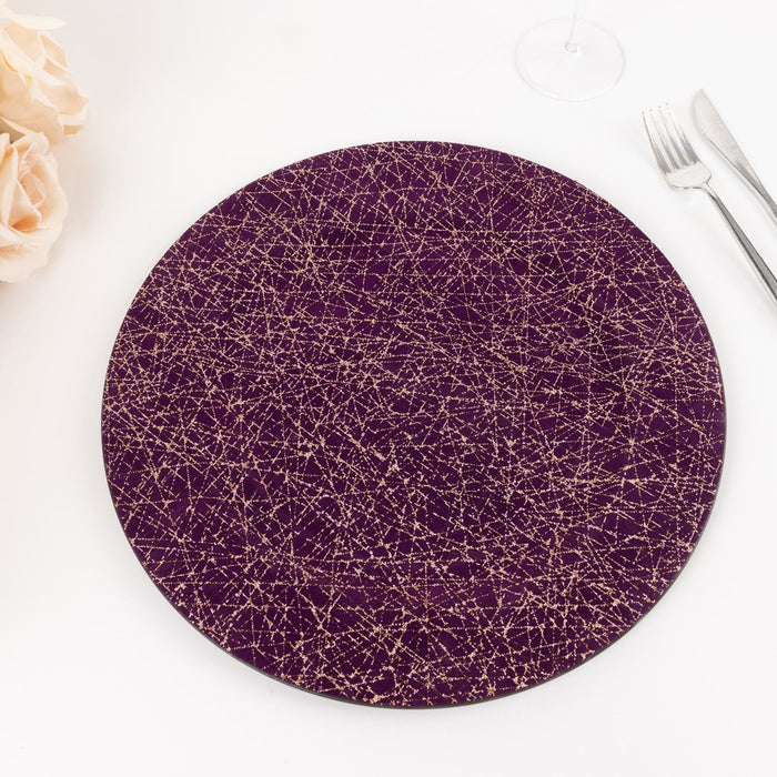 Round purple placemat with gold geometric pattern on a white background.