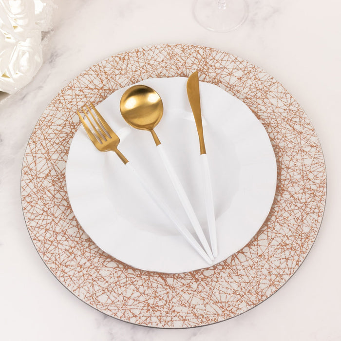 Elegant table setting with gold cutlery and decorative plate.