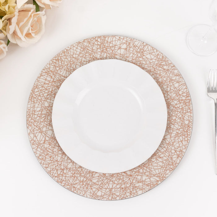 Decorative dinnerware set with patterned charger and white plate on a table.