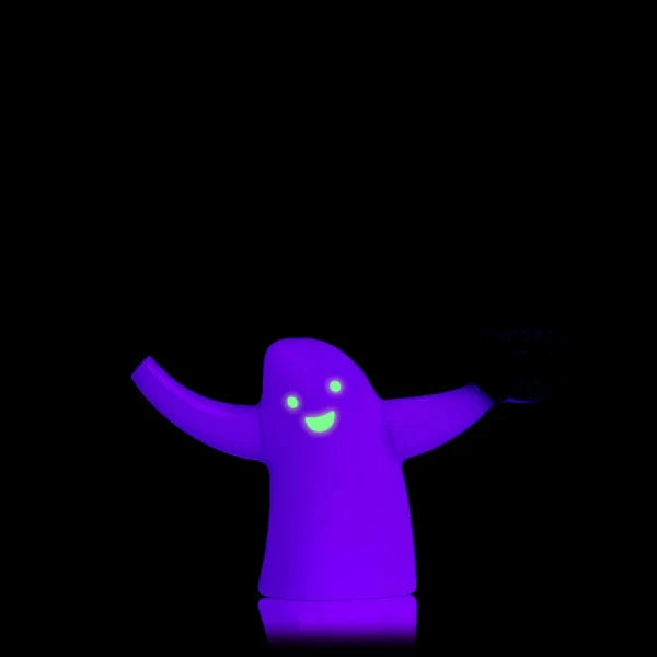 Glowing ghost glass bubbler in the dark with bright face details, showcasing luminous body and side pumpkin bowl.