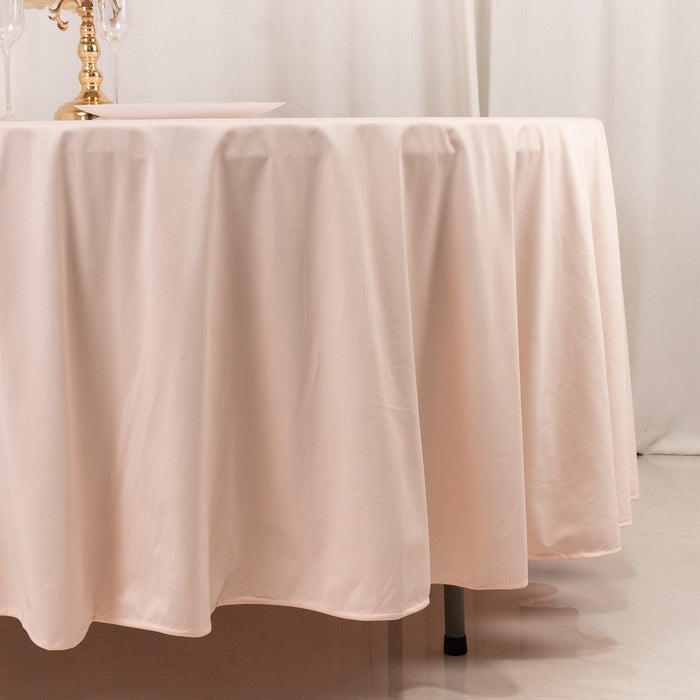 Elegant blush tablecloth draping over a round table.